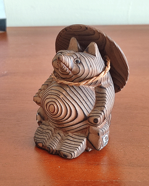 Vintage wooden tanuki (raccoon dog) figurine carved using the Ichii Itto Bori technique with removable hat, showcasing traditional Japanese craftsmanship and natural wood grain.