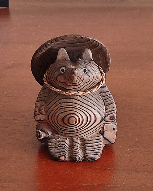 Vintage wooden tanuki (raccoon dog) figurine carved using the Ichii Itto Bori technique with removable hat, showcasing traditional Japanese craftsmanship and natural wood grain.