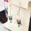 Elegant earrings featuring light blue Chiyogami paper with a Tsuru crane motif, accented by a light blue glass bead, symbolizing peace and longevity. Gift idea from j-okini.com in Malta