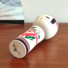 Cylindrical Creative Kokeshi doll by Miho Sasaki, featuring hand-painted chrysanthemums in red, green, and purple, with a rounded top and artist’s signature on the base. Buy online at j-okini.com in Malta