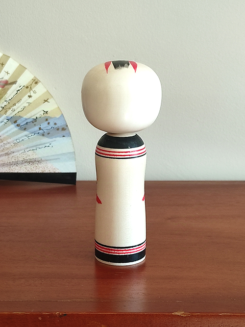 Cylindrical Creative Kokeshi doll by Miho Sasaki, featuring hand-painted chrysanthemums in red, green, and purple, with a rounded top and artist’s signature on the base. Buy online at j-okini.com in Malta