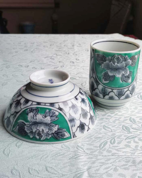 Banko-yaki Yunomi tea cup and rice bowl set featuring bold peony flowers with a vivid green background framed by traditional details, crafted by the Aigama kiln in Yokkaichi, Japan. Available at j-okini.com in Malta.