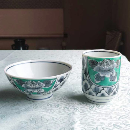 Banko-yaki Yunomi tea cup and rice bowl set featuring bold peony flowers with a vivid green background framed by traditional details, crafted by the Aigama kiln in Yokkaichi, Japan. Available at j-okini.com in Malta.