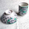 Banko-yaki Yunomi tea cup and rice bowl set featuring bold peony flowers with a vivid green background framed by traditional details, crafted by the Aigama kiln in Yokkaichi, Japan. Available at j-okini.com in Malta.