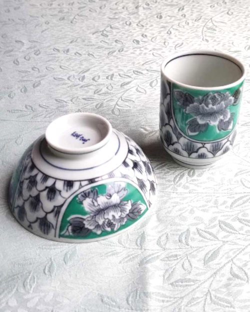 Banko-yaki Yunomi tea cup and rice bowl set featuring bold peony flowers with a vivid green background framed by traditional details, crafted by the Aigama kiln in Yokkaichi, Japan. Available at j-okini.com in Malta.