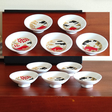 A 5-piece Sakazuki sake cup set featuring Red Fuji with intricate designs of cherry blossoms, waves, and autumn leaves, accented in gold and red for an elegant, celebratory touch. Available at j-okini.com in Malta