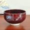 A handmade Kiyomizu-ware Matcha bowl by Okayama Kousha, featuring a deep amber glaze with vibrant blue accents, a low tube shape, and a wide opening for easy use. available at j-okini.com in malta