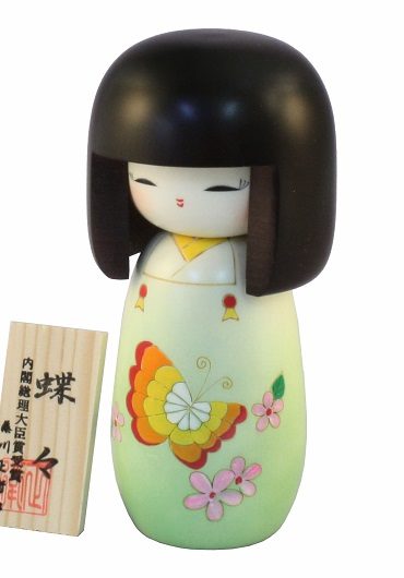Handcrafted Japanese Kokeshi doll 'Chouchou' by artist Fujikawa Shoei, featuring a light green Michiyuki kimono jacket with a butterfly and pink floral design. Available at j-okini.com in Malta