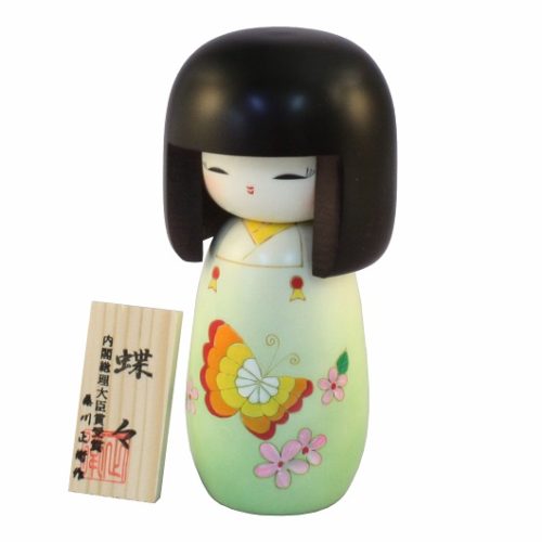 Handcrafted Japanese Kokeshi doll 'Chouchou' by artist Fujikawa Shoei, featuring a light green Michiyuki kimono jacket with a butterfly and pink floral design. Available at j-okini.com in Malta