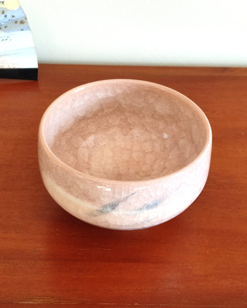 Kiyomizu-ware handmade Matcha bowl by Okayama Kousha, featuring a warm light coral and skin-tone hue with a delicate cracked-glass pattern. Tube-shaped for excellent heat retention, with unique random grey accents on the front. Stamped at the bottom. Made in Japan. Available at j-okini.com in Malta