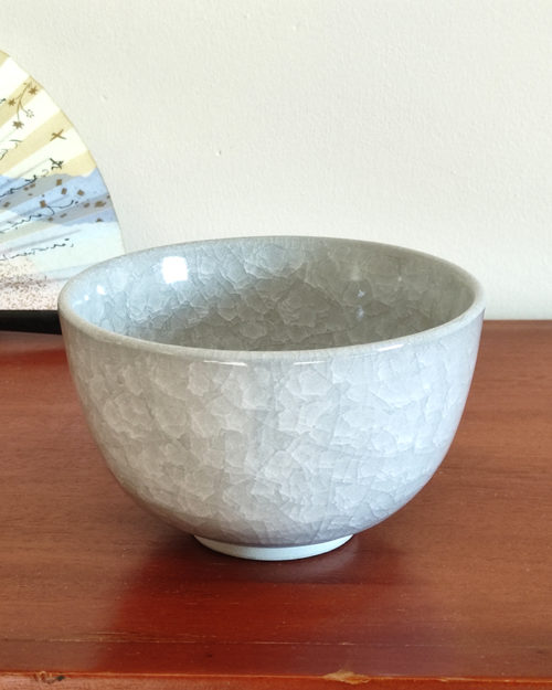 Kiyomizu-ware handmade Matcha bowl by Okayama Kousha, featuring a soft grey blend with a delicate cracked-glass pattern. Classic bowl shape for easy handling, stamped at the bottom. Made in Japan. Available at j-okini.com in Malta