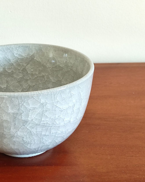 Kiyomizu-ware handmade Matcha bowl by Okayama Kousha, featuring a soft grey blend with a delicate cracked-glass pattern. Classic bowl shape for easy handling, stamped at the bottom. Made in Japan. Available at j-okini.com in Malta