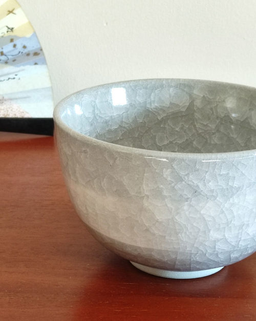 Kiyomizu-ware handmade Matcha bowl by Okayama Kousha, featuring a soft grey blend with a delicate cracked-glass pattern. Classic bowl shape for easy handling, stamped at the bottom. Made in Japan. Available at j-okini.com in Malta