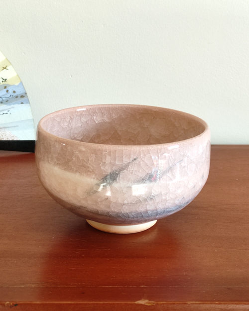 Kiyomizu-ware handmade Matcha bowl by Okayama Kousha, featuring a warm light coral and skin-tone hue with a delicate cracked-glass pattern. Tube-shaped for excellent heat retention, with unique random grey accents on the front. Stamped at the bottom. Made in Japan. Available at j-okini.com in Malta