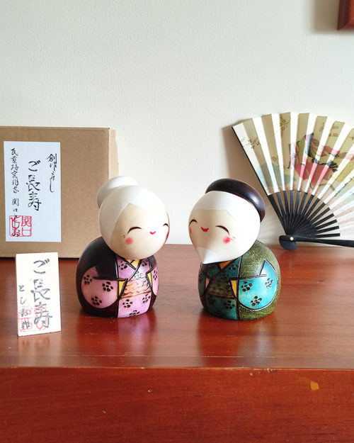 A modern Creative Kokeshi doll set named 'Gochouju' by award-winning artist Sekiguchi Toshio. The dolls depict an elderly couple with kind smiles, dressed in elegant kimono, celebrating longevity and happiness. Handcrafted in Japan. Available at j-okini.com in Malta