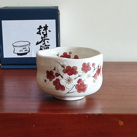 Small Mino ware Matcha bowl with a cream glaze and delicate white and red plum blossom design, perfect for enhancing the beauty of Matcha. Available at j-okini.com in Malta