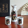 Mino ware porcelain sake set featuring a black Maneki Neko with a smiley face, symbolizing protection and good fortune. Available at j-okini.com in Malta