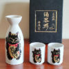 Mino ware porcelain sake set featuring a black Maneki Neko with a smiley face, symbolizing protection and good fortune. Available at j-okini.com in Malta