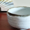 Mino ware Matcha bowl with a white glaze that enhances the green of Matcha, a winding dark green-brown rim, and a wabi-sabi aesthetic, handcrafted in Japan Available at j-okini.com in Malta