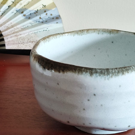 Mino ware Matcha bowl with a white glaze that enhances the green of Matcha, a winding dark green-brown rim, and a wabi-sabi aesthetic, handcrafted in Japan Available at j-okini.com in Malta