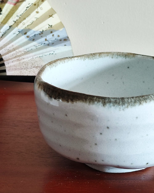 Mino ware Matcha bowl with a white glaze that enhances the green of Matcha, a winding dark green-brown rim, and a wabi-sabi aesthetic, handcrafted in Japan Available at j-okini.com in Malta