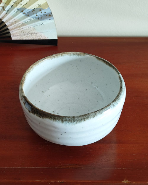 Mino ware Matcha bowl with a white glaze that enhances the green of Matcha, a winding dark green-brown rim, and a wabi-sabi aesthetic, handcrafted in Japan Available at j-okini.com in Malta