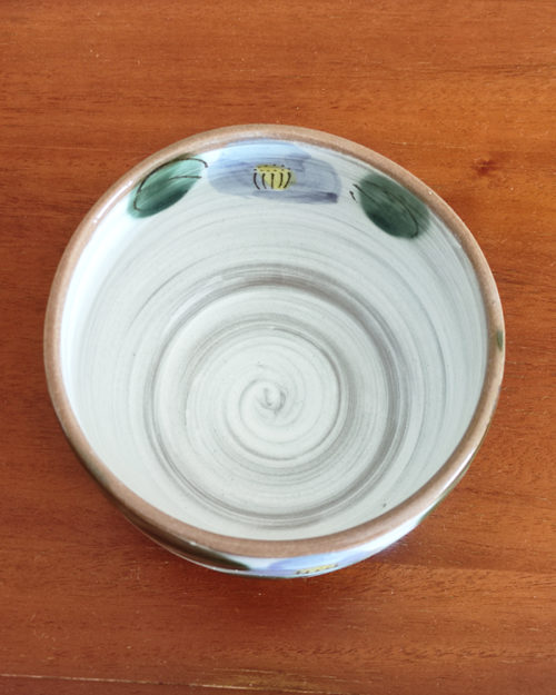 Mino ware Matcha bowl featuring a purple Camellia design with green leaves, a winding dark green-brown rim, and a swirl pattern inside. Made in Japan. Available at j-okini.com in Malta