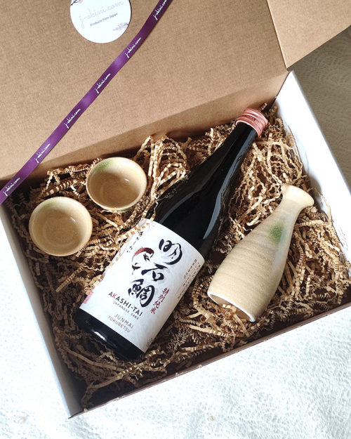 A luxurious Japanese sake gift set featuring a 720ml Akashi-Tai Tokubetsu Junmai sake bottle and a Mino ware sake set with a glazed tokkuri bottle (170ml) and two matching sake cups, accented with soft green highlights. Made in Japan. Available at j-okini.com in Malta