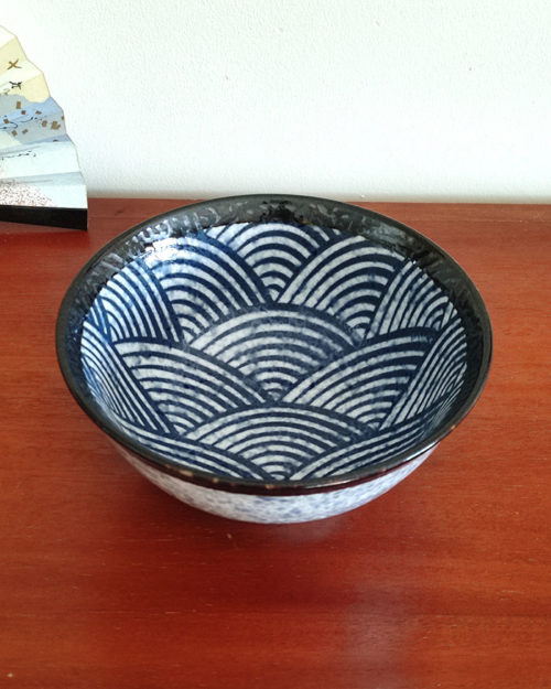 A traditional Japanese Mino ware donburi bowl featuring a deep blue Seigaiha wave pattern. With a 600ml capacity, 16cm diameter, and 8cm height, it's ideal for rice dishes, udon, or instant noodles. Beautifully crafted with a smooth glaze, showcasing the elegance of Japanese ceramics. Made in Japan. Available at j-okini.com in Malta