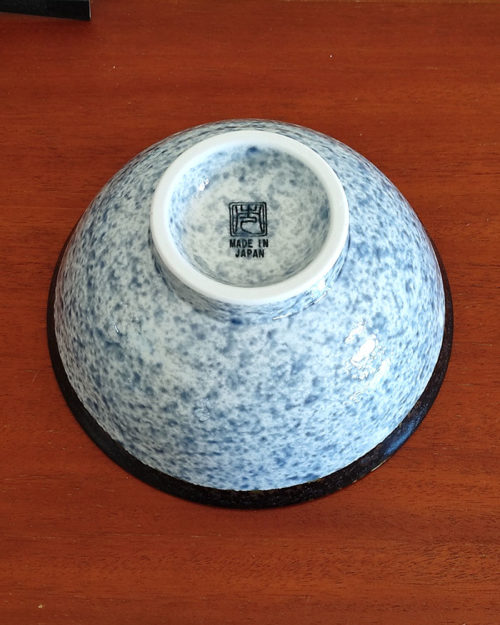 A traditional Japanese Mino ware donburi bowl featuring a deep blue Seigaiha wave pattern. With a 600ml capacity, 16cm diameter, and 8cm height, it's ideal for rice dishes, udon, or instant noodles. Beautifully crafted with a smooth glaze, showcasing the elegance of Japanese ceramics. Made in Japan. Available at j-okini.com in Malta