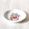 A charming Maneki-Neko small dish made from white porcelain, featuring a lucky cat with red and gold patches and the 福 (Fuku) character symbolizing happiness. Perfect for serving soy sauce or small appetizers, or as a decorative accent. Made in Japan, handcrafted Mino ware. Available at j-okini.com in Malta