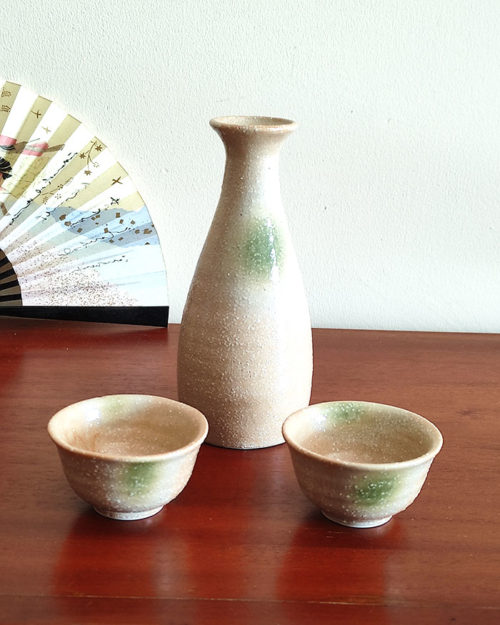 A glazed Kiseto Sake Set with a beige tokkuri bottle and matching sake cups, each featuring soft green accents and a smooth, speckled finish. Made in Japan. Available at j-okini.com in Malta